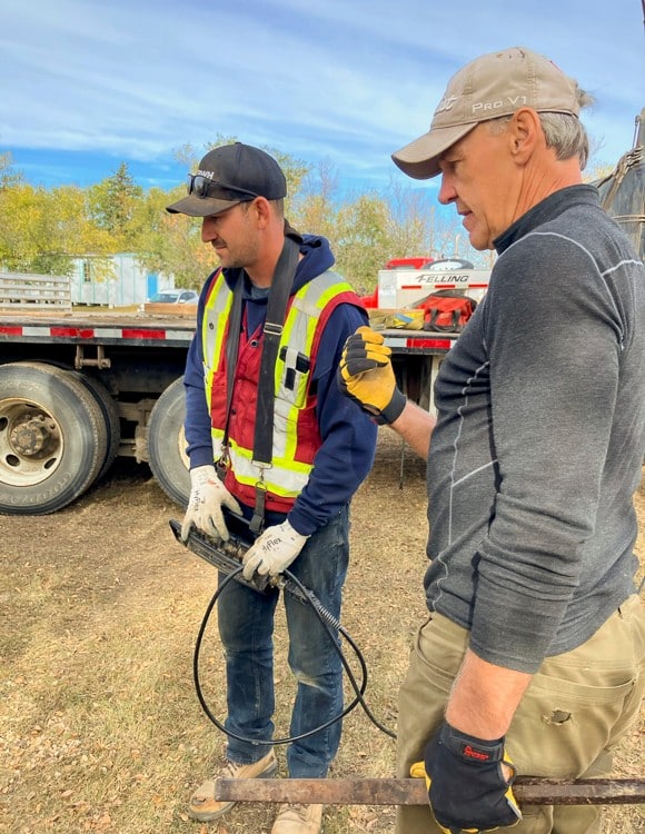 Team members drilling holes for pins, following expert advice.